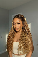 Woman with long, wavy hair styled with a clip against a neutral background, Obroi