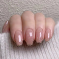 Nail art with a pink and gold gradient on a neutral background, Obroi