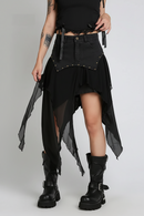 Person wearing a black, studded, and layered skirt with black boots on a gray background, Obroi