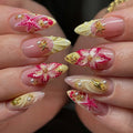 Nails with pink, yellow, and gold floral designs on a blurred background, Obroi