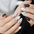 Close-up of hands with black and white marbled nail design on a blurred background, Obroi