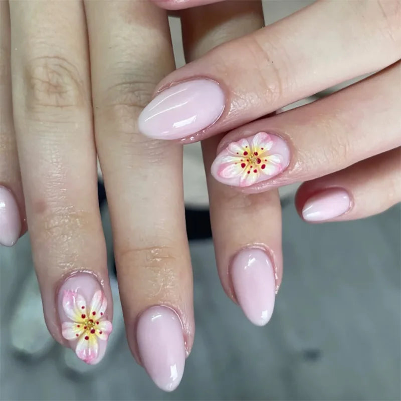 Close-up of hands with pink nail polish and floral designs on a blurred background