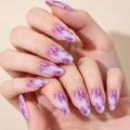 A close-up of hands with long almond-shaped nails decorated in a pink and white marble pattern, set against a soft beige background, Obroi