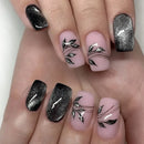 Nails with pink and black floral design on a white background,Obroi