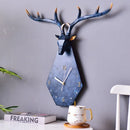 Decorative wall clock shaped like a deer head with antlers on a gray wall, Obroi