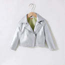 A metallic silver faux-leather moto jacket for kids, hanging on a wooden hanger against a plain white background, Obroi