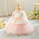 A toddler girl's formal party dress displayed on a wooden dress form mannequin. The dress features a white lace bodice with pink satin bows, a layered light pink tulle skirt, and a matching sheer pink veil with bows, Obroi