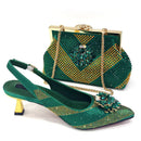 A green and gold embellished slingback high-heel shoe shown in front of a matching green and gold rhinestone clutch bag with a gold chain strap, on a white background, Obroi