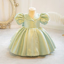 Light green dress on a mannequin against a decorative wall, Obroi