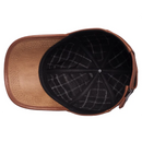 Top-down view of a brown leather baseball cap showing the curved brim, textured leather side panels, and a black interior with a white grid pattern, Obroi