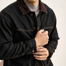 Person wearing a dark denim jacket with a plain background, Obroi