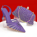 Purple high-heeled shoe and matching handbag with rhinestone details on a red background, Obroi