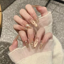 Hand with transparent nail polish and gold accents on a neutral background, Obroi