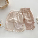 Obroi Pair of baby pants with ruffled edges on a light background