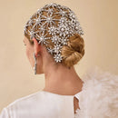 Woman wearing an ornate headpiece with pearls and crystals on a beige background, Obroi