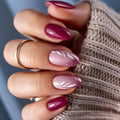 Close-up of a hand with pink and purple gradient nails wearing a beige sweater, Obroi
