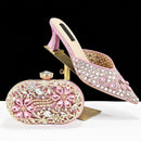 Pink high-heeled shoes and matching clutch with rhinestone embellishments on a black background, Obroi 