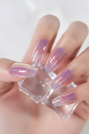 Hand with purple and clear nail polish holding a clear nail file against a white background, Obroi