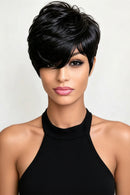 A woman modeling a short, layered black wig with a side-swept bang and soft textured ends against a plain light background, Obroi