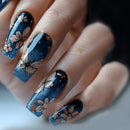 Nails with blue nail polish and floral designs on a neutral background, Obroi