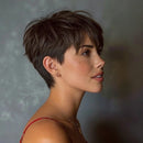 A woman in profile wearing a short, textured dark brown pixie cut with side-swept bangs, shown against a soft gray studio background, Obroi