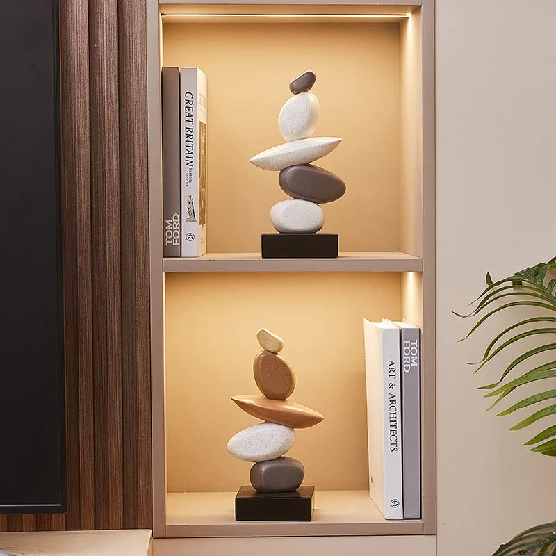 Decorative stone stack on a shelf with books in a softly lit room, Obroi