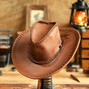 Brown leather cowboy hat with braided band on a wooden stand, rustic background, Obroi