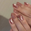 Close-up of a hand with pink glittery nail polish on a neutral background, Obroi
