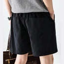 Person wearing black shorts with a gray top and white background, Obroi