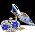 Decorative blue shoe and matching clutch with 'Obroi' branding on a black background