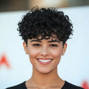 Woman with short, curly black hair smiling against a blurred background, Obroi