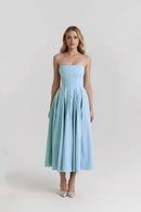 Woman wearing a light blue strapless dress on a white background, Obroi