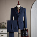 Navy blue suit on a mannequin with a patterned tie, standing against a neutral wall.
