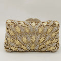 Gold clutch bag with intricate design and embellishments on a light gray background, Obroi