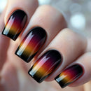 Nails with a gradient design of black, red, and yellow on a blurred background, Obroi