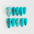Turquoise nail art tips with red polka dots and silver embellishments on a white background, Obroi