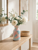 Decorative vase with floral arrangement on a wooden surface, Obroi