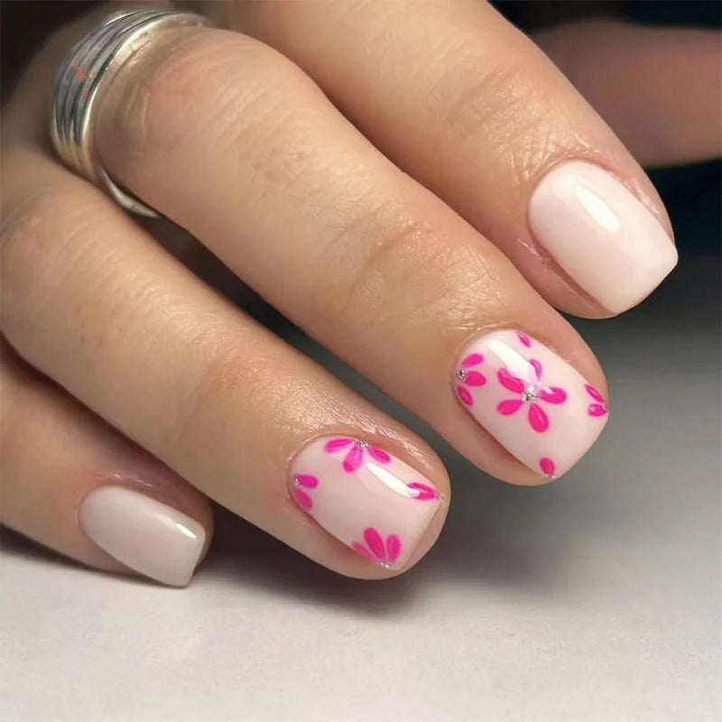 Hand with pink floral nail design on a neutral background, Obroi