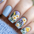 Nails with floral design featuring flowers and beads on a light blue background, Obroi