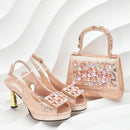Pair of embellished high-heeled shoes with a matching handbag on a white background, Obroi