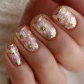 Nails with floral design featuring white daisies and gold accents on a light pink background, Obroi