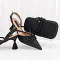 Black high-heeled shoes with decorative elements and a matching black clutch on a white background, Obroi