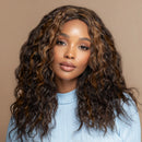 Woman with long, wavy hair wearing a light blue top against a beige background, Obroi