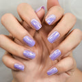 Hand with purple nail polish on a neutral background, Obroi