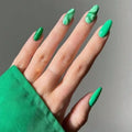 Hand with green nail polish against a gray background, Obroi