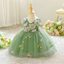 Green floral dress on a mannequin with flowers in the background, Obroi