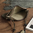 Green leather pouch with drawstring on a wooden surface, Obroi