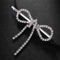 Silver bow-shaped hairpin with rhinestones on a black background, Obroi