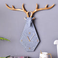 Decorative wall clock with deer antlers on a gray wall, Obroi
