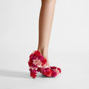 Floral high-heeled shoes worn by a person on a plain background, Obroi